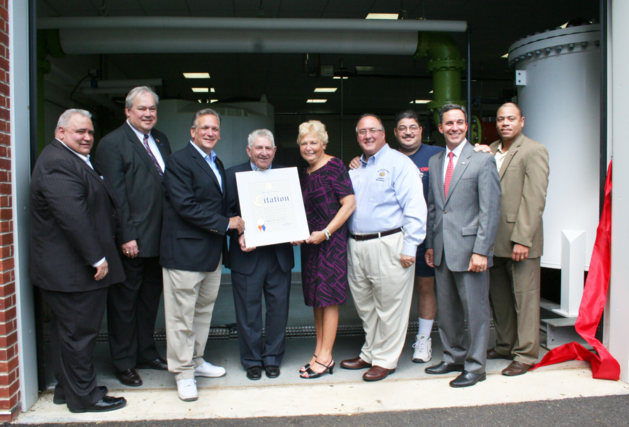 (L-R) Hicksville Water District Board of Commissioners Chairman Karl Schweitzer, Town of Oyster Bay Receiver of Taxes James Stefanich, Hicksville Water District Board of Commissioners Chairman Nicholas Brigandi, Nassau County Executive Edward Mangano, Assemblyman Michael Montesano, Legislator Rose Walker, Hicksville Community Council Vice President Stan Kobin, Senator Jack Martins and Hicksville Chamber of Commerce President Lionel J. Chitty come together at Hicksville Water District’s Plant #6 as the County Executive presents a citation to the Hicksville Water District in recognition of their contributions to the Hicksville community.
